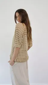 Blusa beige de punto calado con lurex y mangas cortas.