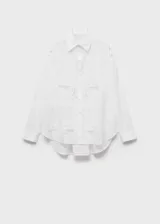 Camisa blanca de algodón con bordados florales, de corte oversize, manga larga con puños abotonados y cuello camisero.