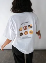Remera blanca de manga corta con estampa de galletas en la espalda y logo de la marca en el frente.