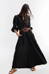 Pantalón de lino negro, súper ancho, de tiro medio-alto con tablas delanteras y elástico en la parte trasera.