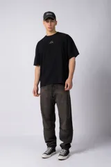 Remera color crudo de corte oversize, con cuello redondo y mangas cortas. Presenta un pequeño bordado de un sol en el centro del pecho.