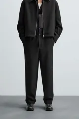 Pantalón negro de corte recto, con cintura elástica, bolsillos laterales y trasero.