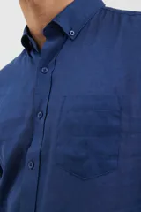 Camisa celeste de lino y algodón, de corte clásico, con cuello button-down y manga larga.