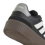 Championes Adidas Court Block Bold de cuero sintético negro con las tres tiras blancas y suela marrón.