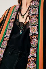 Saco largo con estampado de flores y rayas verticales en tonos naranja, verde y negro.