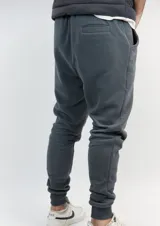 Pantalón de jogging gris topo con puños ajustados, cordón ajustable en la cintura y logo bordado en dorado. Confeccionado en algodón extra suave.