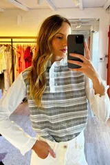 Blusa rosada con mangas largas, cuello con volados y estampado de líneas verticales.