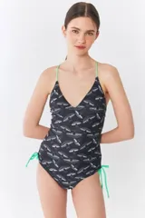 Traje de baño entero negro con estampado exclusivo y tiras cruzadas en la espalda.