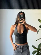 Top negro de ecocuero con escote halter y tachas plateadas.