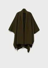 Poncho verde militar de tejido de punto grueso con ribetes negros en contraste y cuello alto.