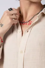 Camisa blanca de lino con cuello clásico, manga larga con puños abotonados y corte holgado. 