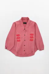 Camisa de jean oversized color rosa, con escote en V bajo, cuello camisero y mangas abullonadas con puños elásticos. Tiene bolsillos delanteros, cierre con botones metálicos y bordado de flores en la parte superior.