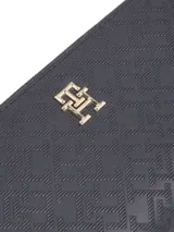 Billetera Tommy Hilfiger con cierre de cremallera, diseño integral con monogramas TH en relieve y insignia del monograma TH en la parte delantera.