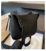 Cartera de cuero vegano color negro, con asa larga y cadena extraíble.