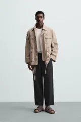 Pantalón negro de lino, corte recto y relaxed fit, con cintura elástica ajustable con cordón, bolsillos laterales y traseros.