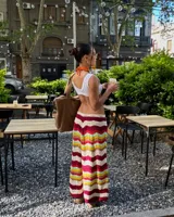 Pollera larga tejida a crochet con diseño de ondas horizontales en tonos borgoña, crema, amarillo, celeste y verde.