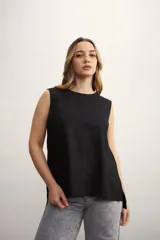 Blusa color crema sin mangas, de lino, con cuello redondo y corte recto.