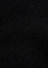 Minifalda negra de tweed con corte evasé y cierre trasero invisible.