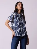 Blusa de algodón con estampado animal print en tonos grises, cuello redondo y manga corta.