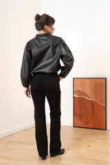 Camisa beige de efecto piel con cuello clásico, mangas largas abullonadas y cierre frontal con botones a tono.