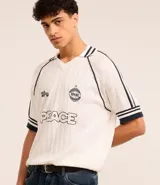 Camisa polo de punto color blanco con rayas azul marino en cuello y mangas. Tiene bordados localizados y lettering.