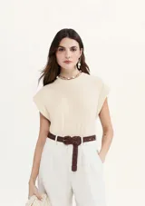 Blusa color crema de tejido acanalado, con cuello redondo y mangas cortas con hombreras.