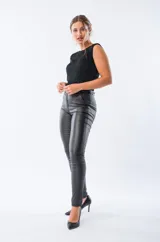 Pantalón negro de corte ajustado, con terminaciones engomadas, tiro alto, bolsillo delantero funcional y falso bolsillo trasero.