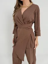 Conjunto color beige de lino, compuesto por un blazer cruzado con lazo para atar y un pantalón de corte recto con cintura elástica.