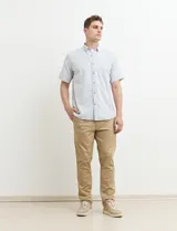 Camisa de manga corta a rayas verticales celestes y blancas, con cuello abotonado y corte clásico.