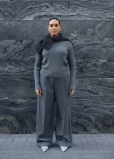 Sweater gris de punto canalé con cuello barco y mangas largas.