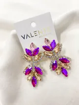Caravanas con diseño florido en tonos dorados, rosa y fucsia, adornadas con cristales.