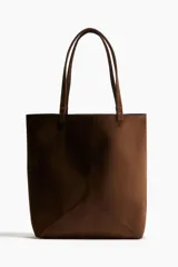 Cartera tipo tote bag color marrón, con asas finas y costuras decorativas.