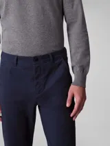 Pantalón chino de corte slim color azul marino, confeccionado en algodón y elastano. Presenta cierre con cremallera y botón, diseño clásico de cuatro bolsillos y logo de Calvin Klein bordado en la parte posterior.