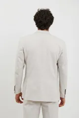 Saco beige de corte clásico, con solapas de muesca, cierre de dos botones y bolsillos laterales con solapa.