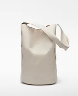 Bolso tipo tote color crudo, con correa de hombro ancha y bolsillo interno con cierre.