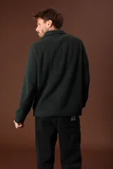 Sweater verde oscuro de punto con cuello alto y cierre de cremallera parcial. Tejido de canalé vertical.