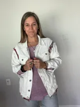 Campera de jean oversize, color rojo desgastado, con aplicaciones de tapicería multicolor de estilo étnico en hombros y ruedo, y terminaciones desflecadas.