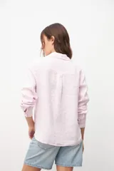 Camisa de manga larga color rosa pastel, con cuello clásico y cierre frontal con botones.