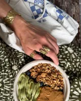 Anillo de diseño orgánico y macizo, realizado artesanalmente en bronce. Presenta una estructura abierta con dos piezas de forma irregular y textura rugosa.