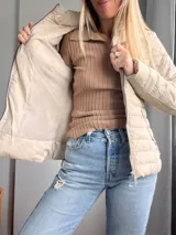Campera acolchada color beige, con cierre frontal y diseño entallado.