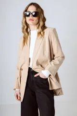 Blazer color beige con doble botonadura, solapas de muesca y corte holgado.