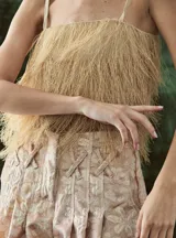 Top de rafia con diseño de flecos, ideal para un look destacado y moderno.