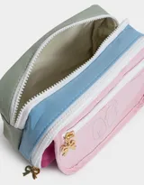 Cartuchera rectangular de tela estampada multicolor con divisiones internas, bolsillo frontal de PVC transparente con estampado de ositos y cierre con cremallera. Incluye un dije metálico con forma de moño.