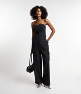 Pantalón de vestir negro, de corte recto, con bolsillos cargo laterales, cintura lisa y pliegues delanteros.