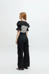 Blusa negra de tejido de punto con escote redondo y mangas cortas abullonadas con detalle de broderie.