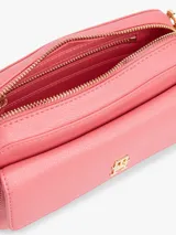 Bandolera Tommy Hilfiger color rosa con logo dorado en el frente y correa de tela a rayas.