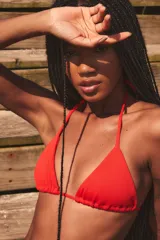 Conjunto de bikini negro con corpiño triangular y bombacha con tiras finas.