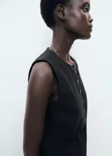 Chaleco negro con cuello redondo, sin mangas y cierre frontal con botones.