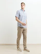 Camisa de manga corta a rayas verticales celestes y blancas, con cuello abotonado y corte clásico.