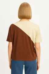 Remera manga corta de viscosa, con diseño color block en negro y beige, corte holgado y cuello redondo.
